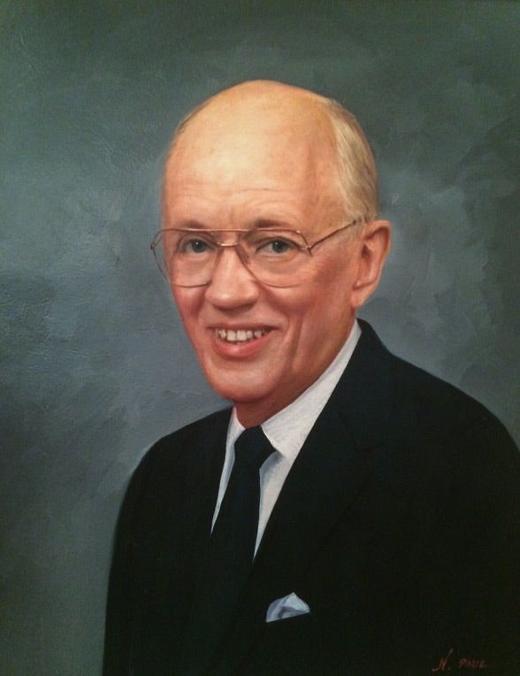 A man in a suit and tie is smiling for the camera