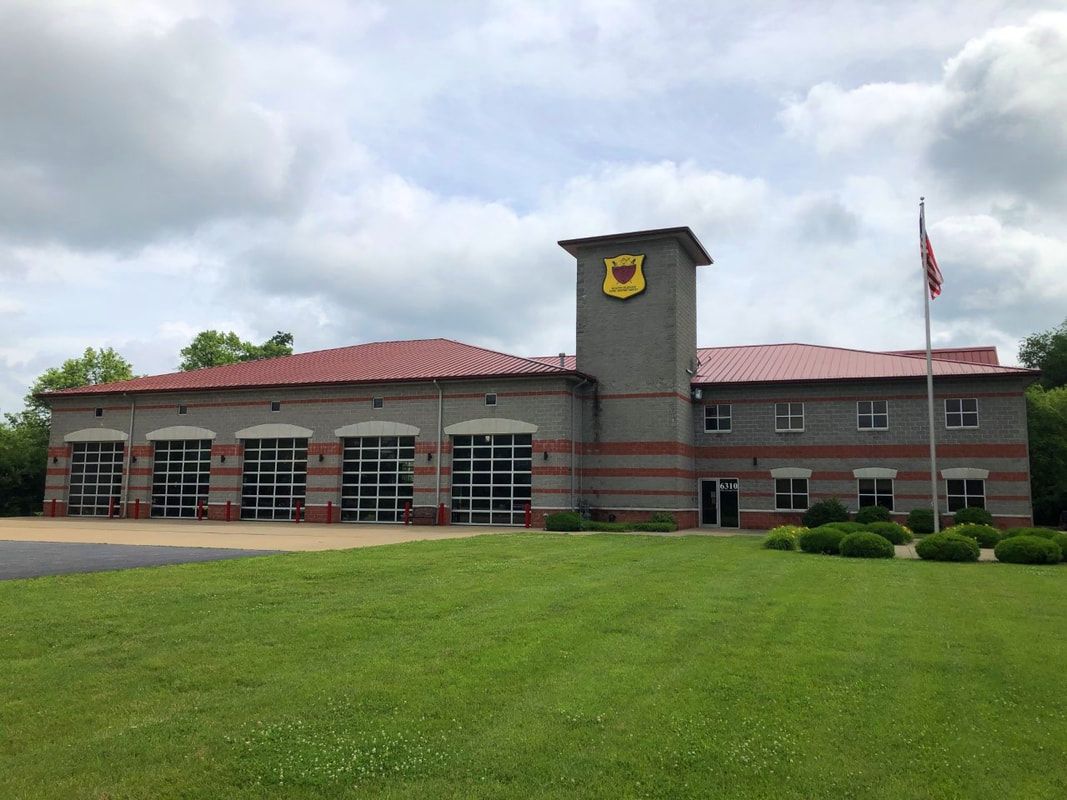 A large building with a red roof and a flag in front of it.
