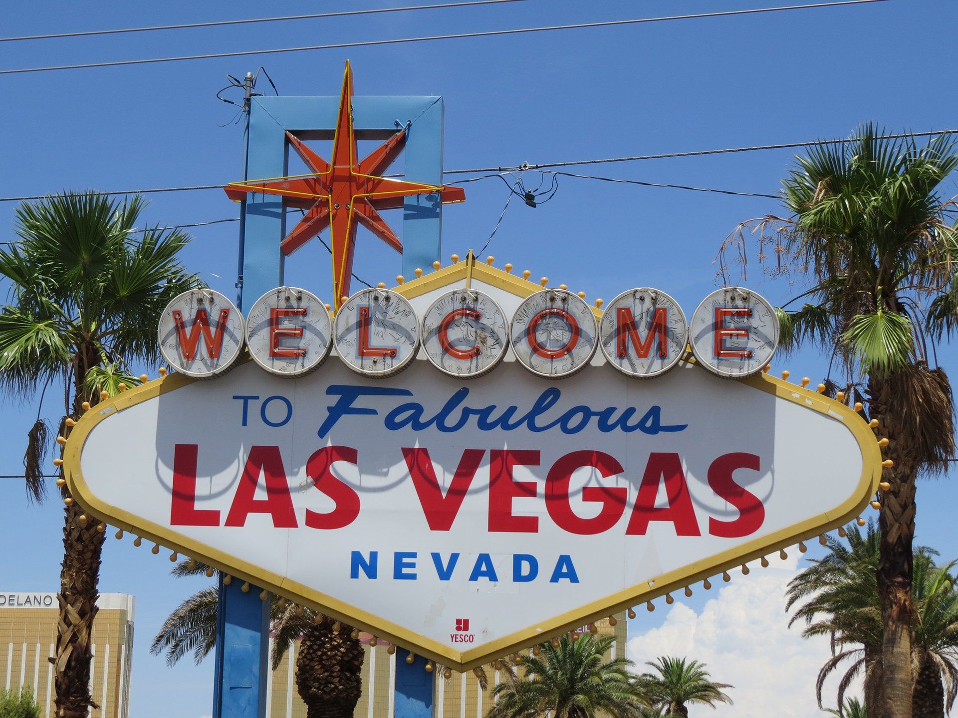 Welkom bij het fantastische Las Vegas-bord, een iconisch wegwijzerbord, een blauwe lucht en palmbomen.