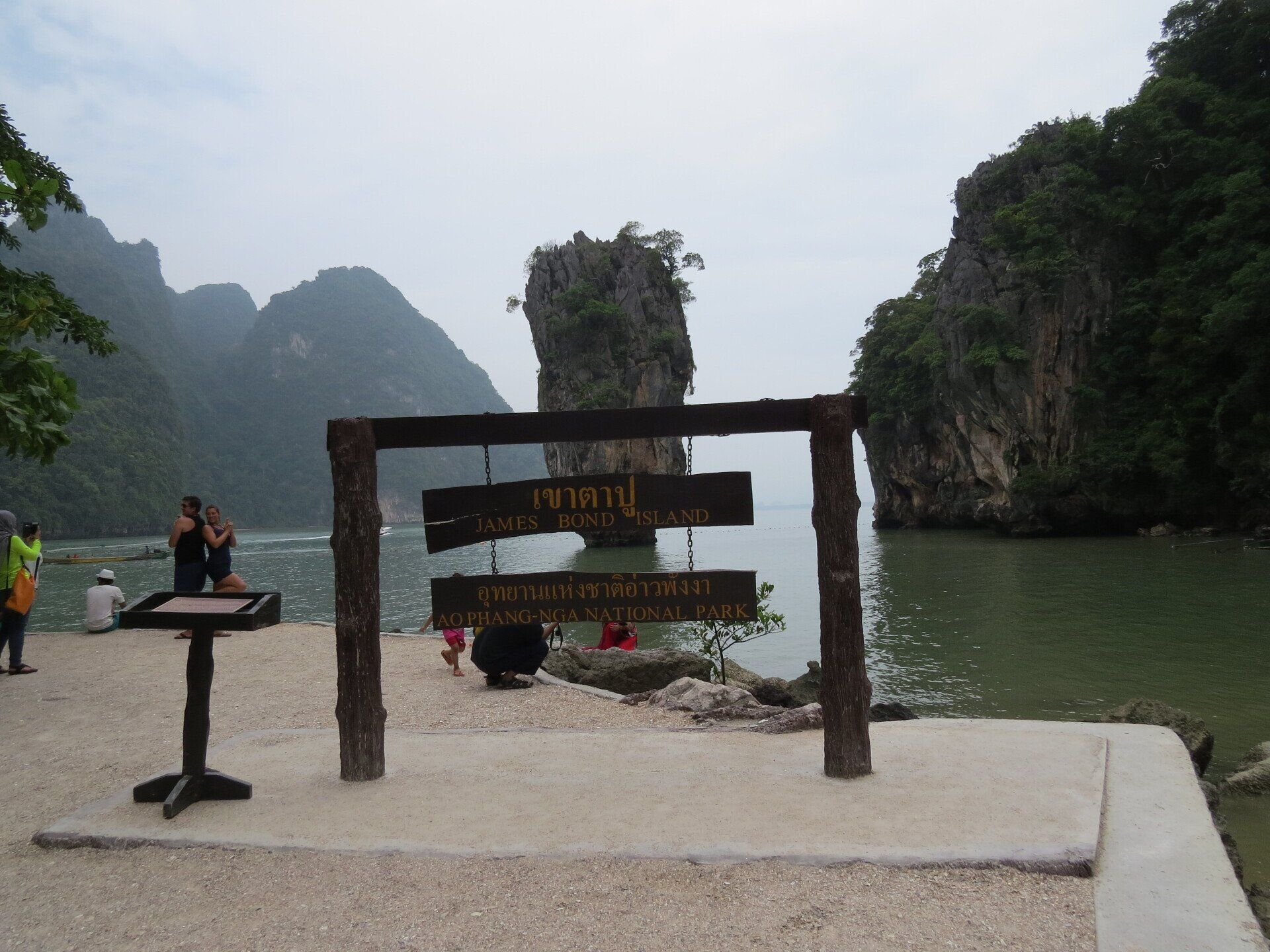 Bord met Thaise tekst en kalksteenformaties in het water bij Phang Nga Bay, Thailand.