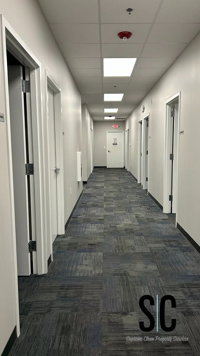 A long hallway with a lot of doors and a carpeted floor