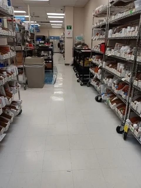 A pharmacy aisle with lots of shelves and carts