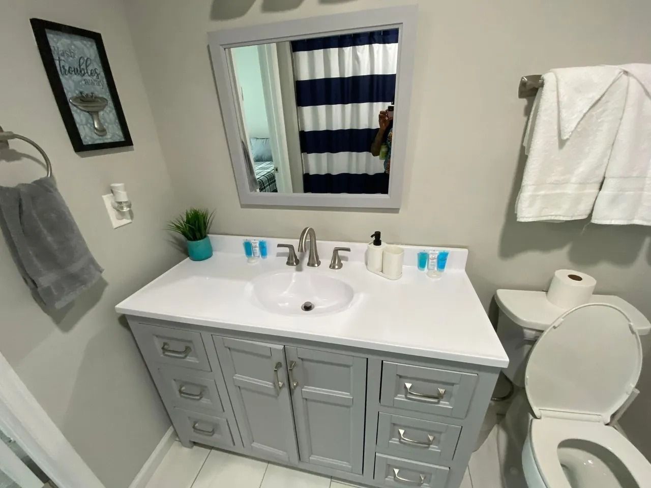 A bathroom with a sink , toilet and mirror.