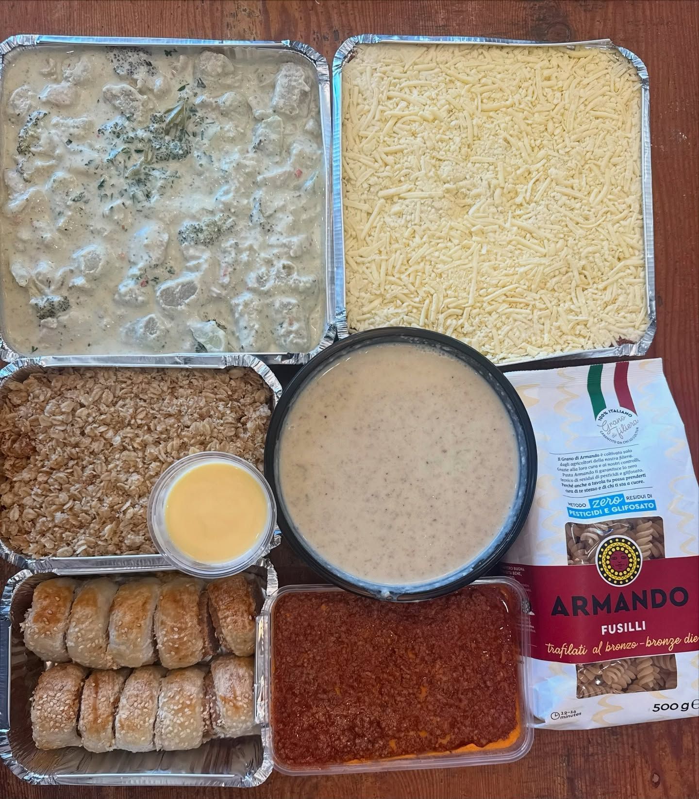 Prepared meal components: pasta, sauce, bread, toppings, and sides.