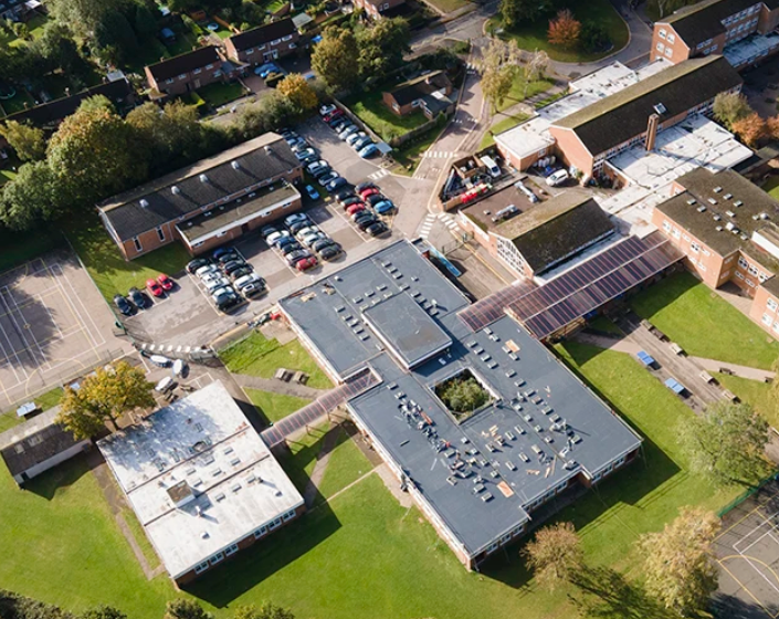 A little girl with her hands and face covered in paint.