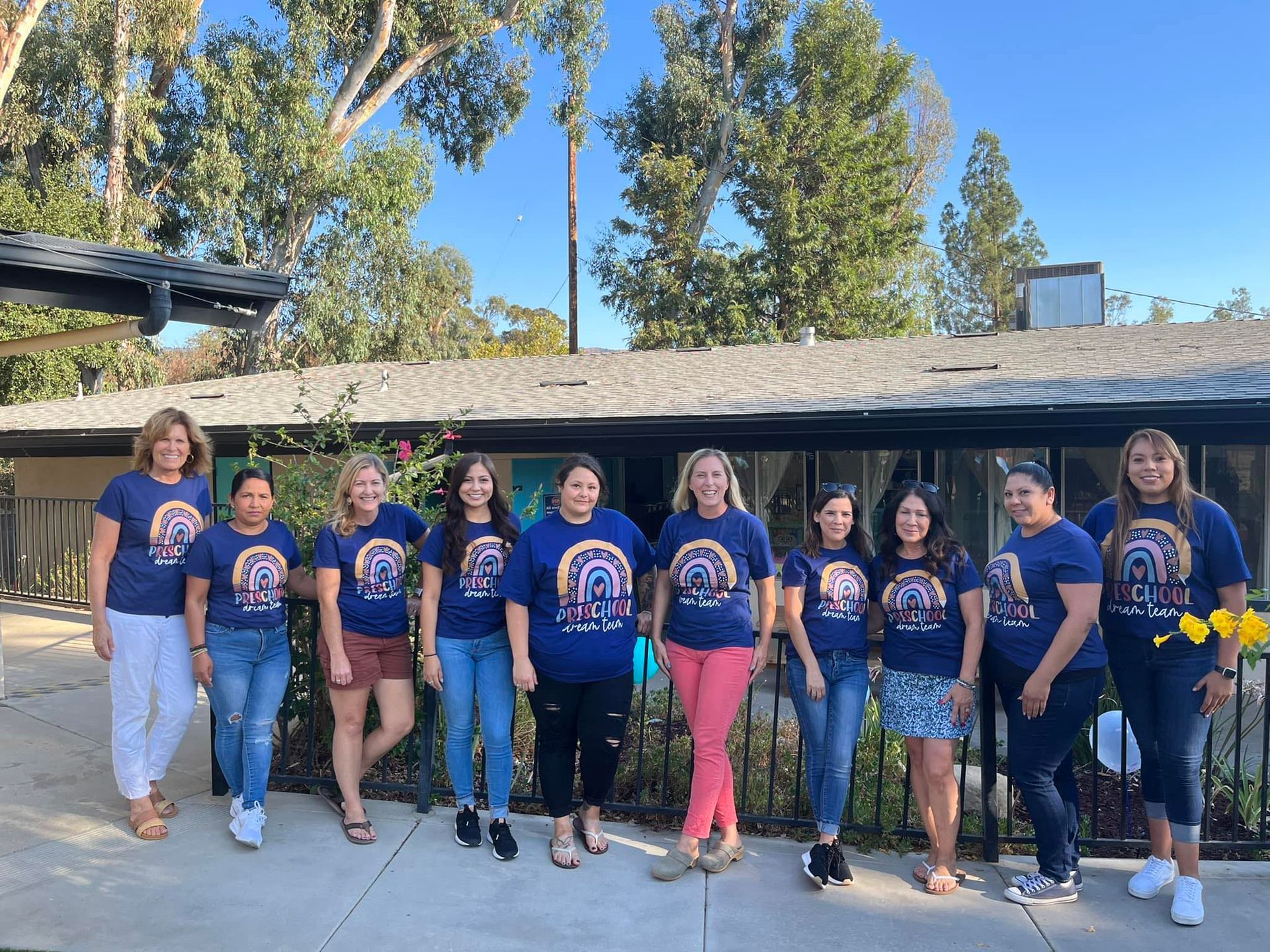 A group of women are posing for a picture in front of a building.
