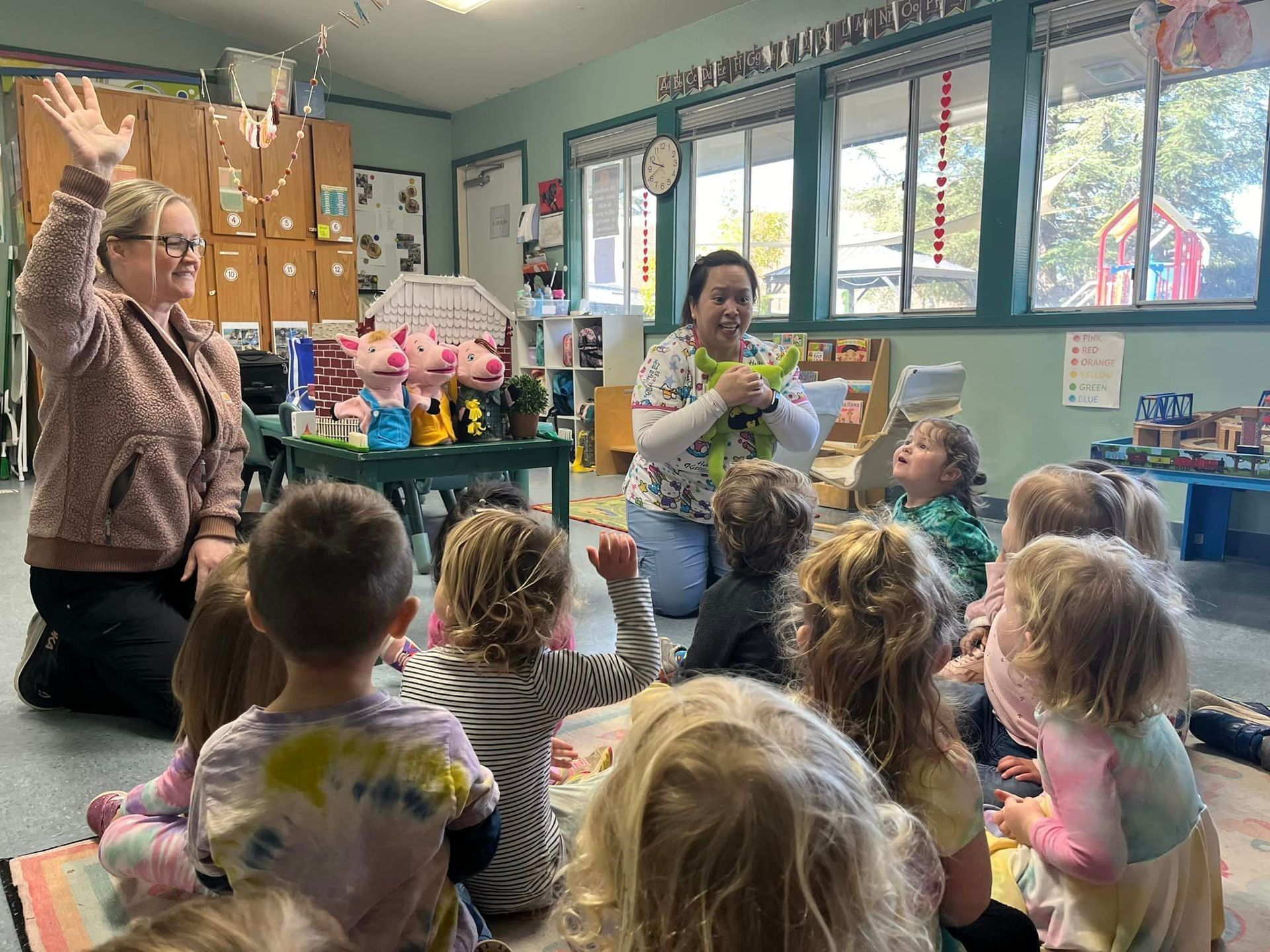 A woman is reading a book to a group of children in a classroom.