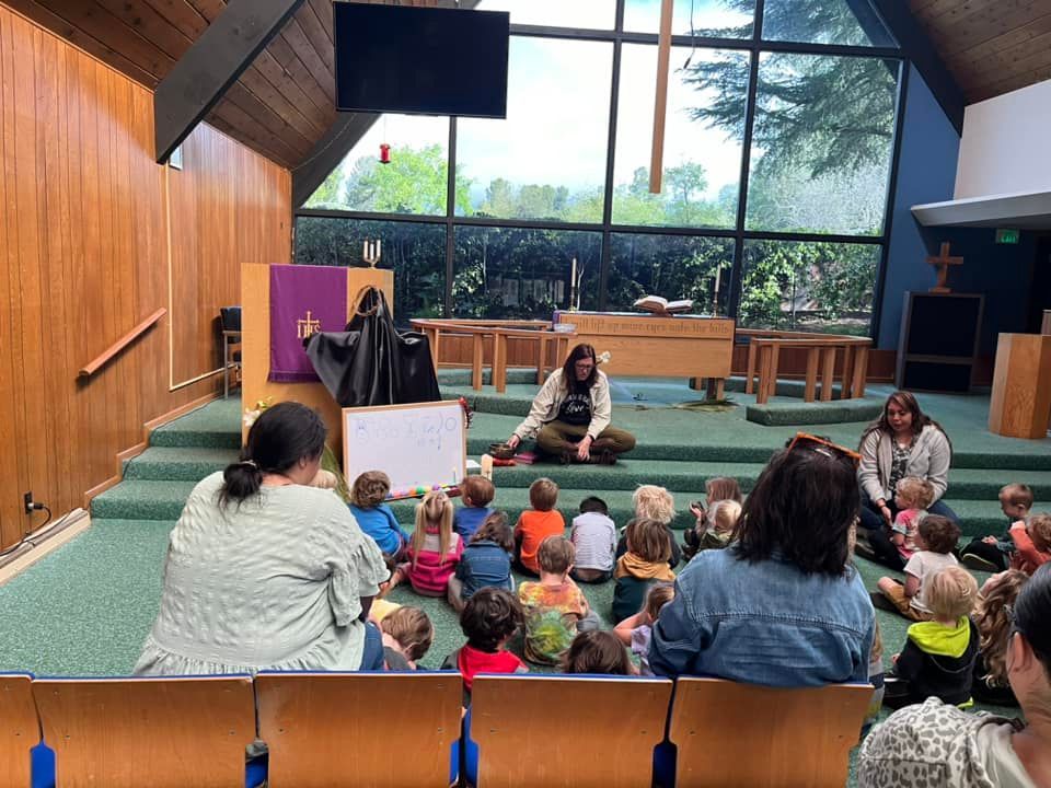 A group of people are sitting on the floor in a church.