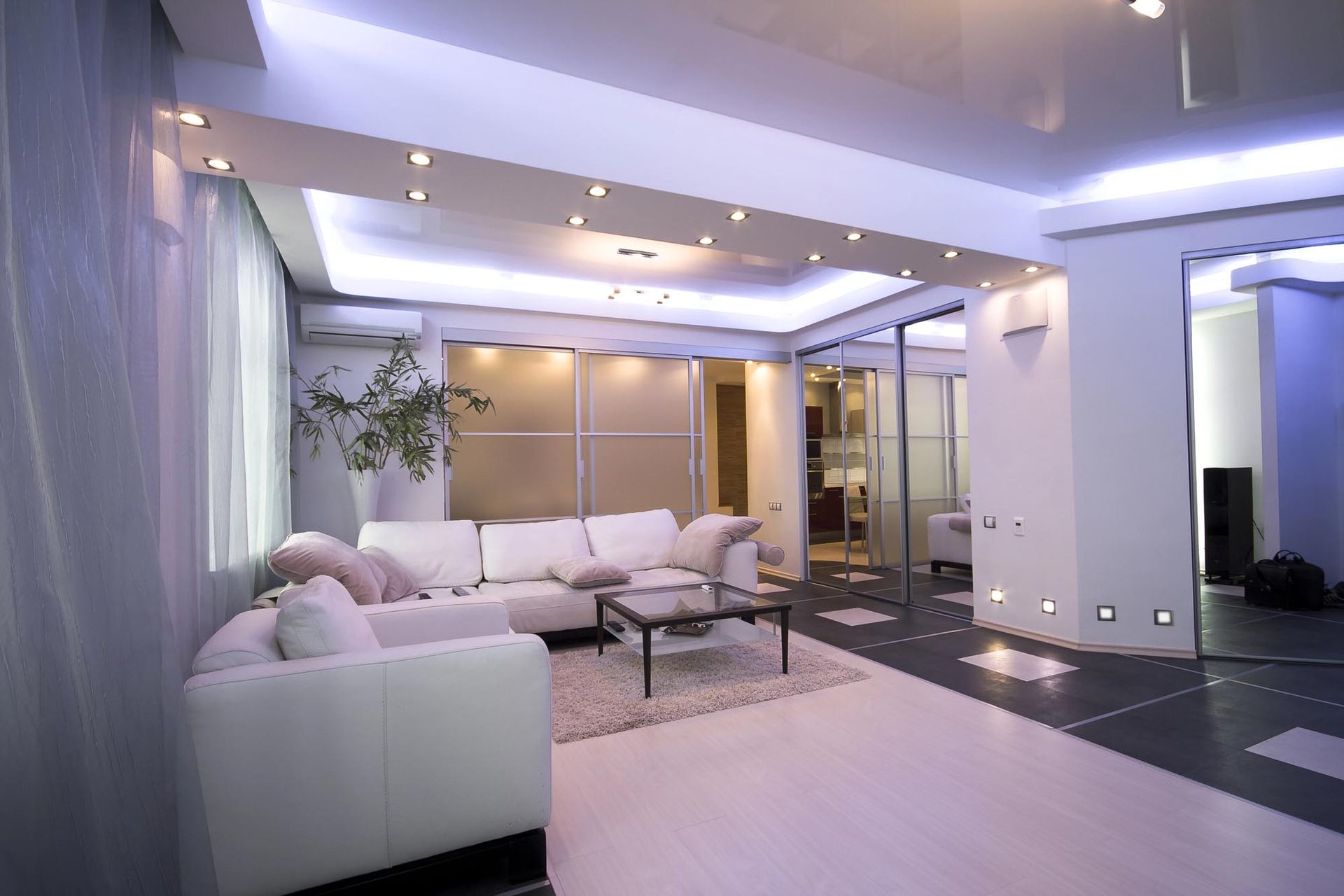 Soggiorno moderno con divano bianco, tavolino da caffè e illuminazione da incasso.