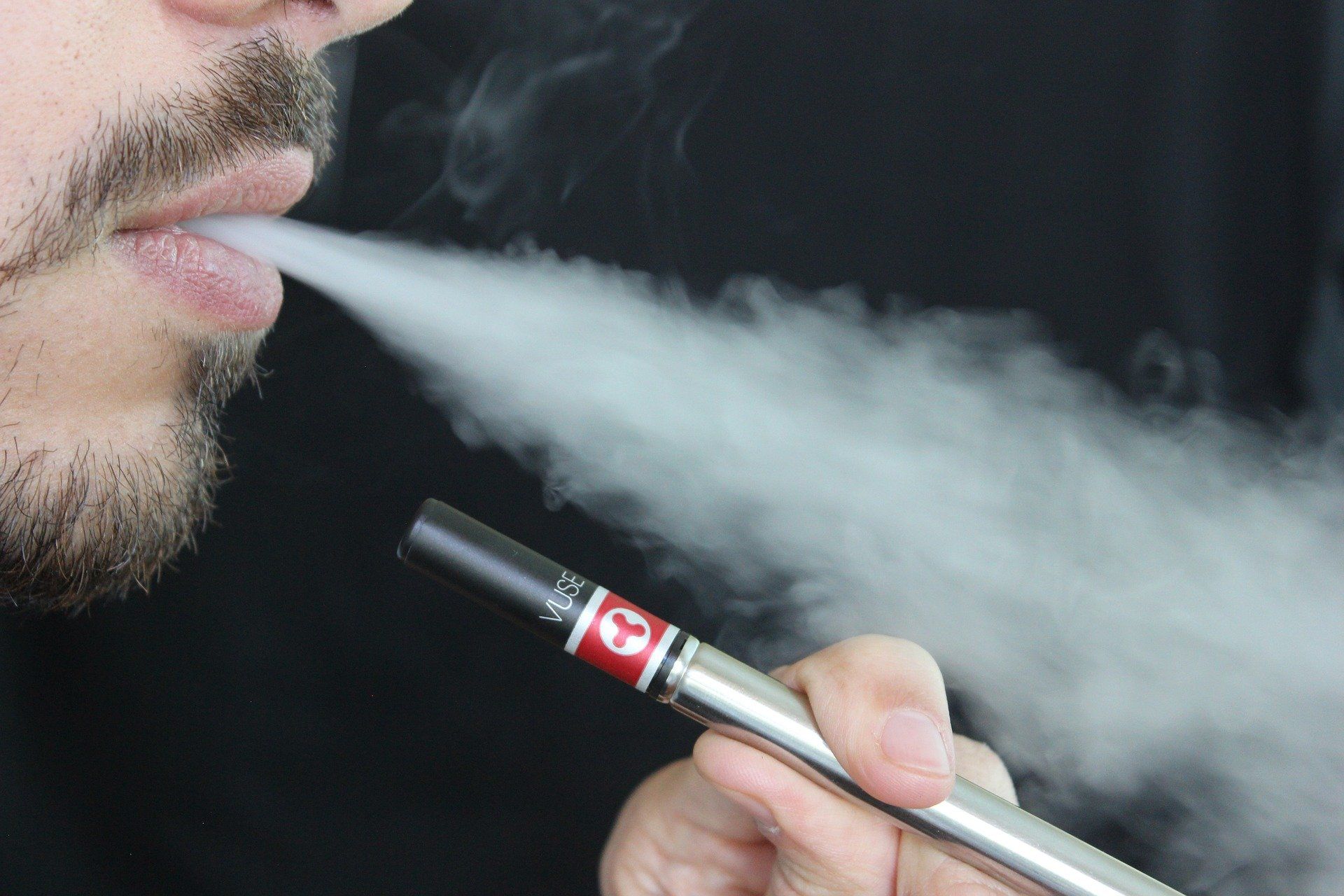 Man vaping an e-cigarette with nicotine