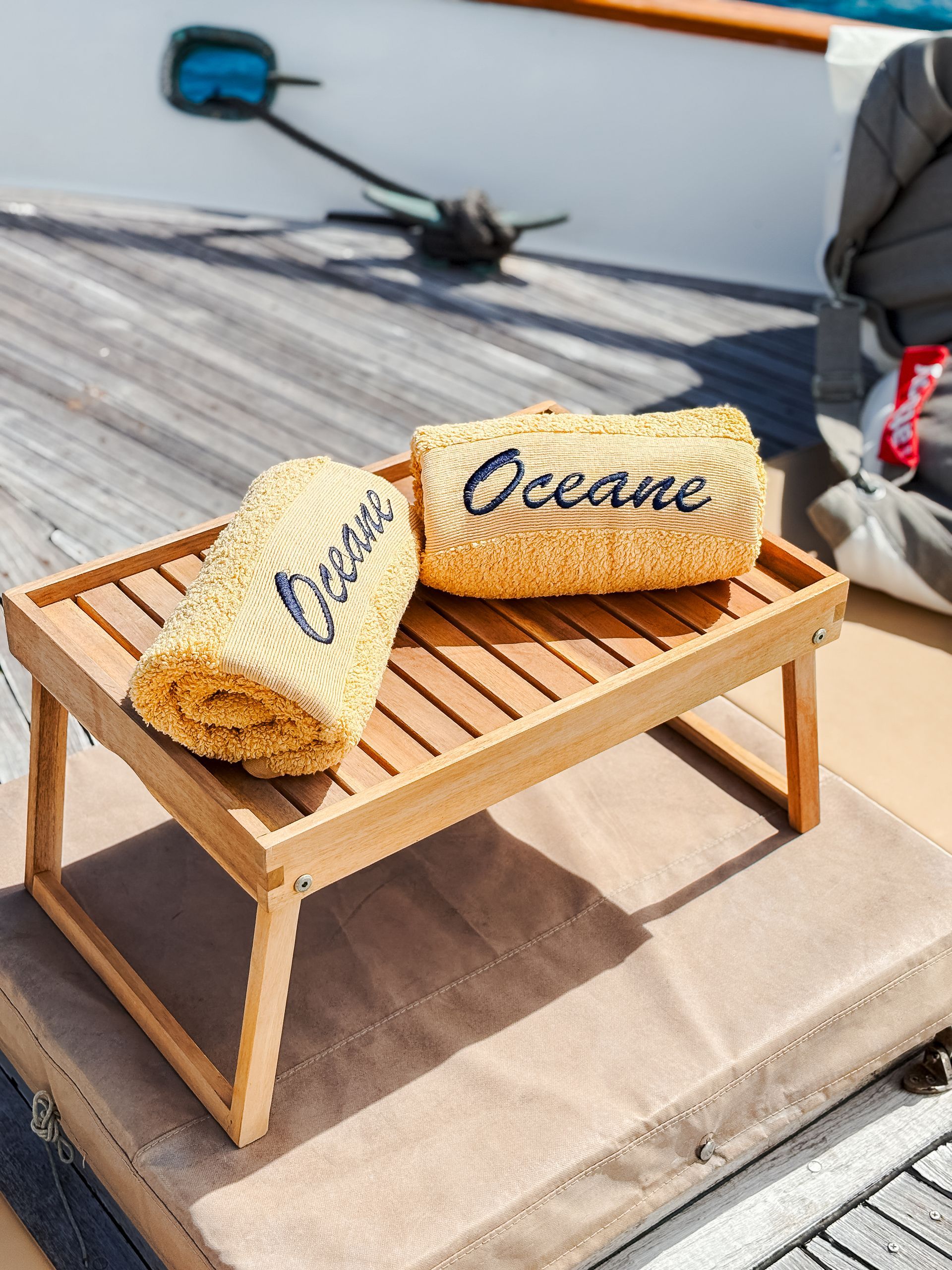Two rolled, embroidered towels labeled 