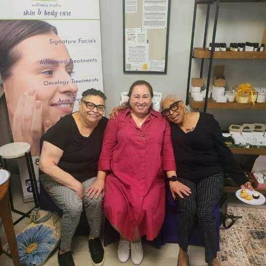 Marija sits between two happy clients at her wellness studio in Summerville, SC.