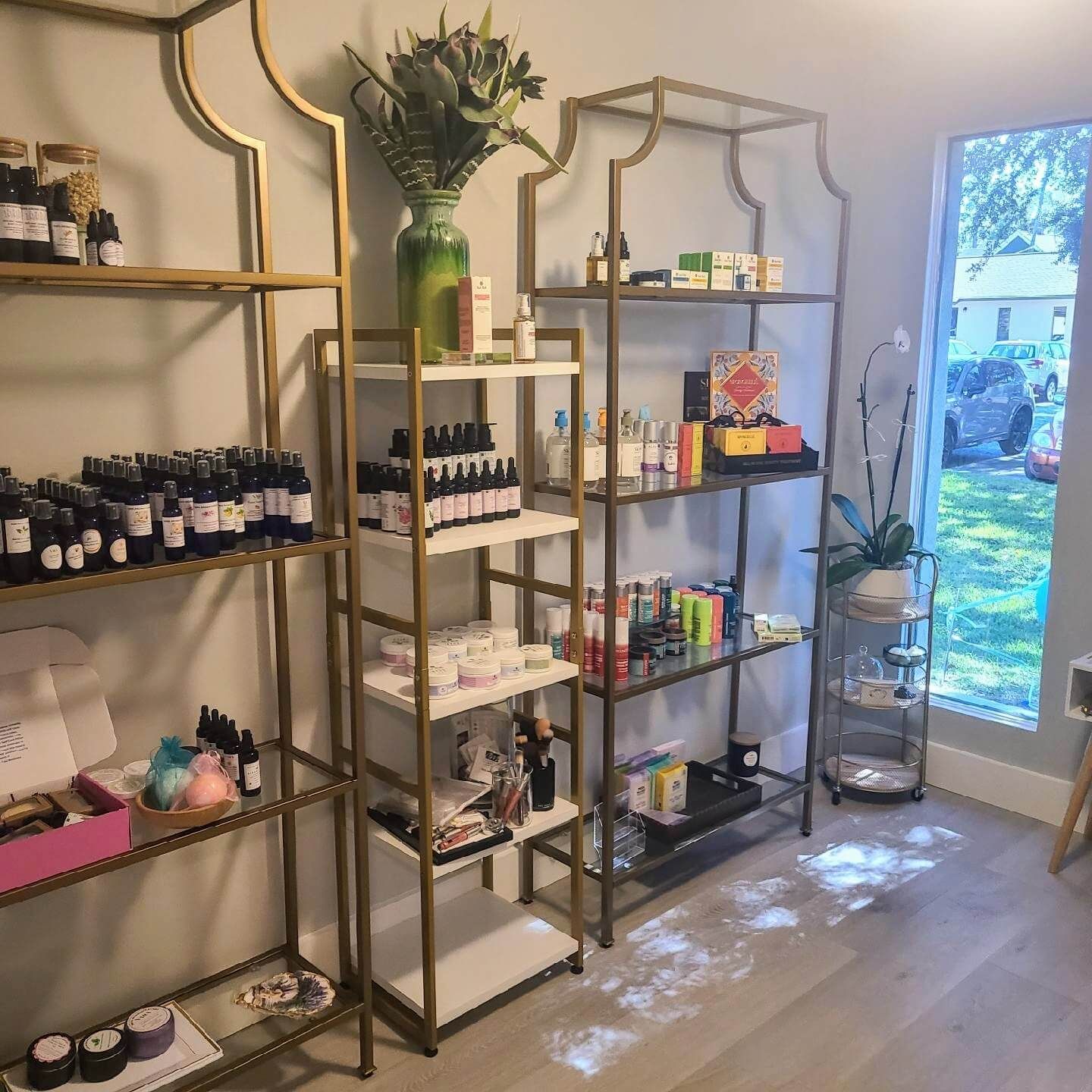 Display shelves in Marija's wellness studio in Summerville, SC, showcasing various skincare products.