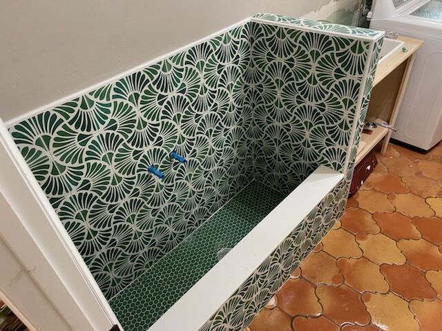 Patterned tiled dog bath station with green non-slip floor and built-in wash area