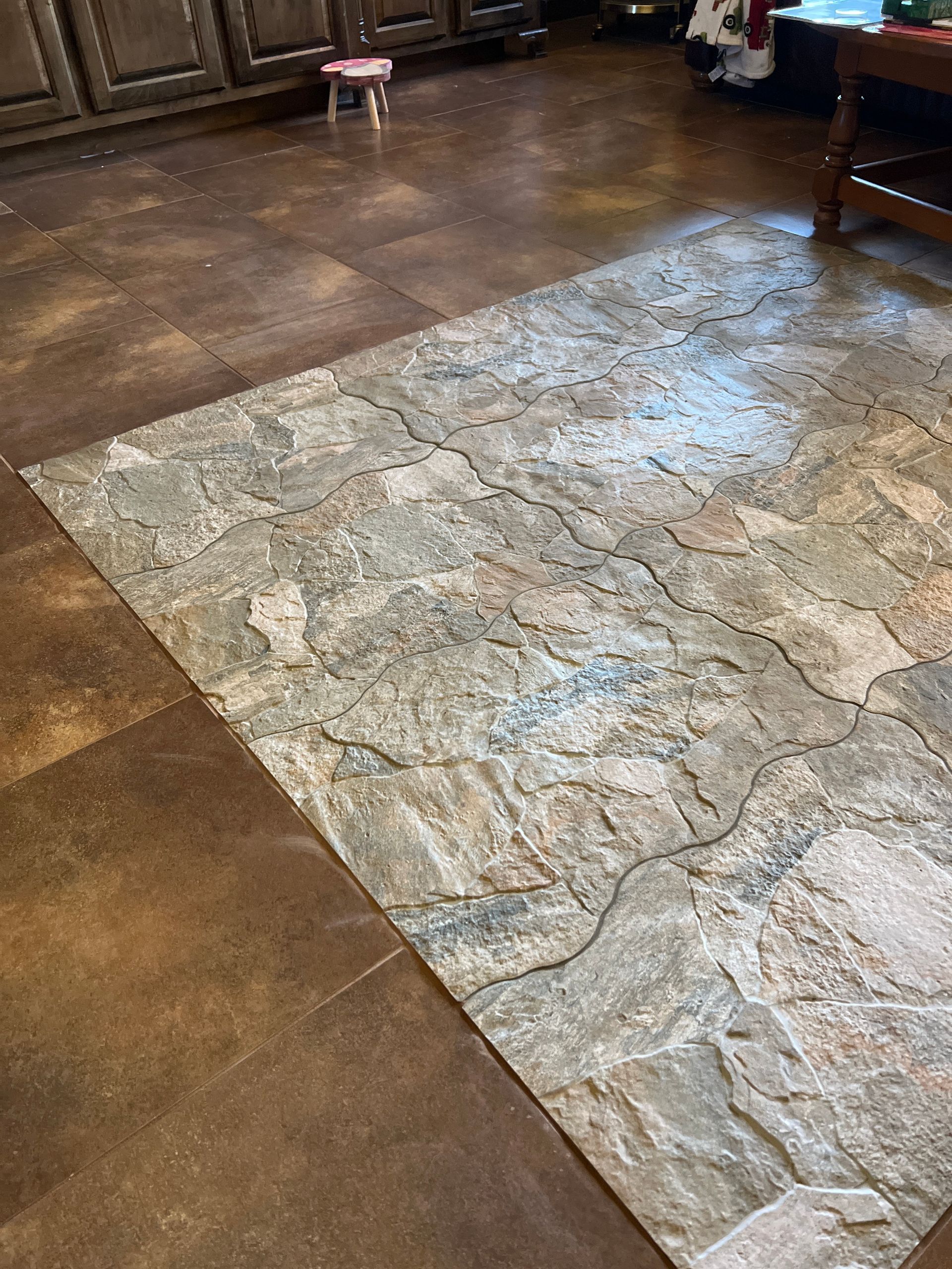 Living room with a large stone-pattern rug on a brown floor near dark wood furniture