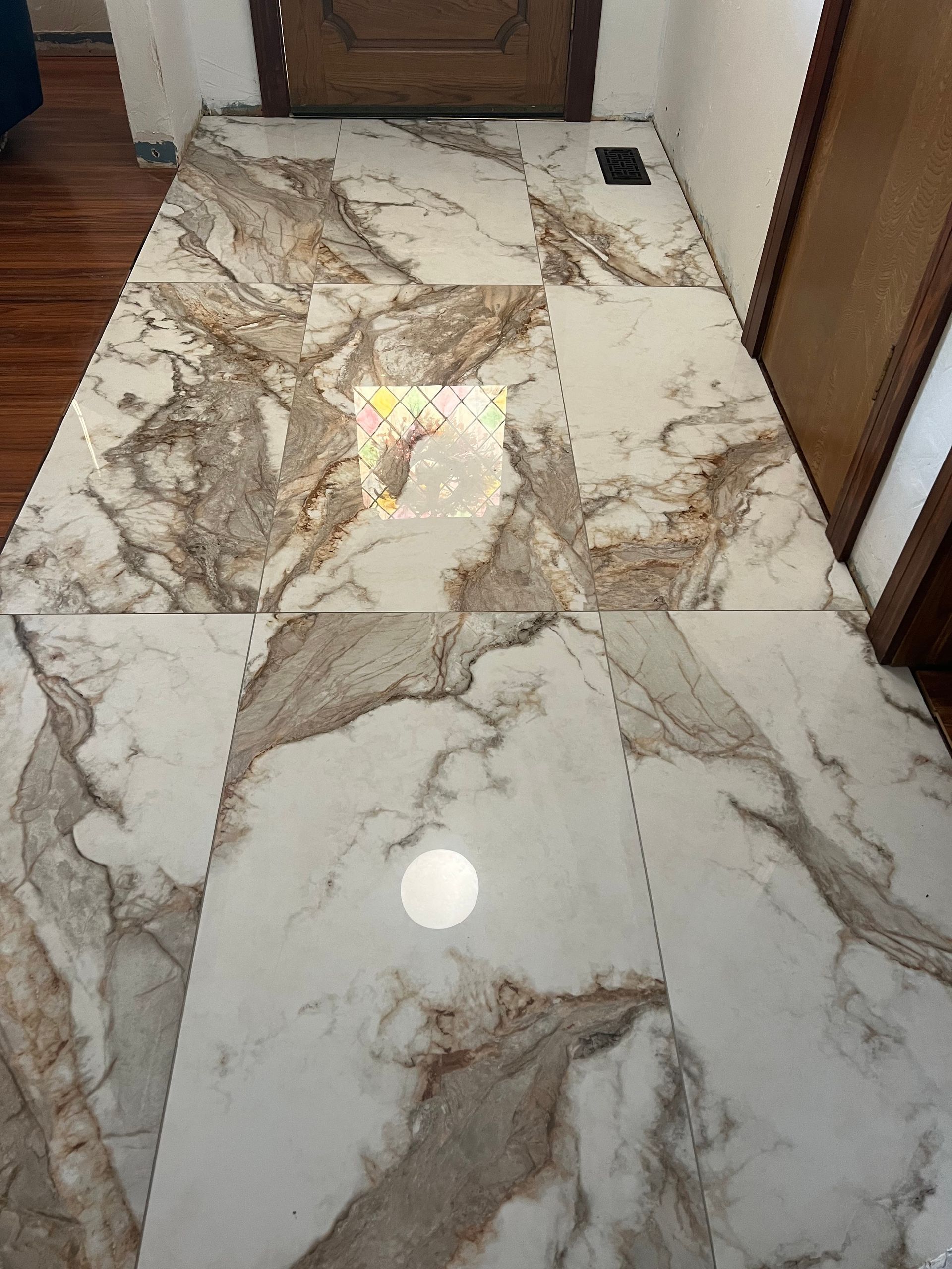 Shiny marble-pattern tile floor in a hallway with doors on both sides.