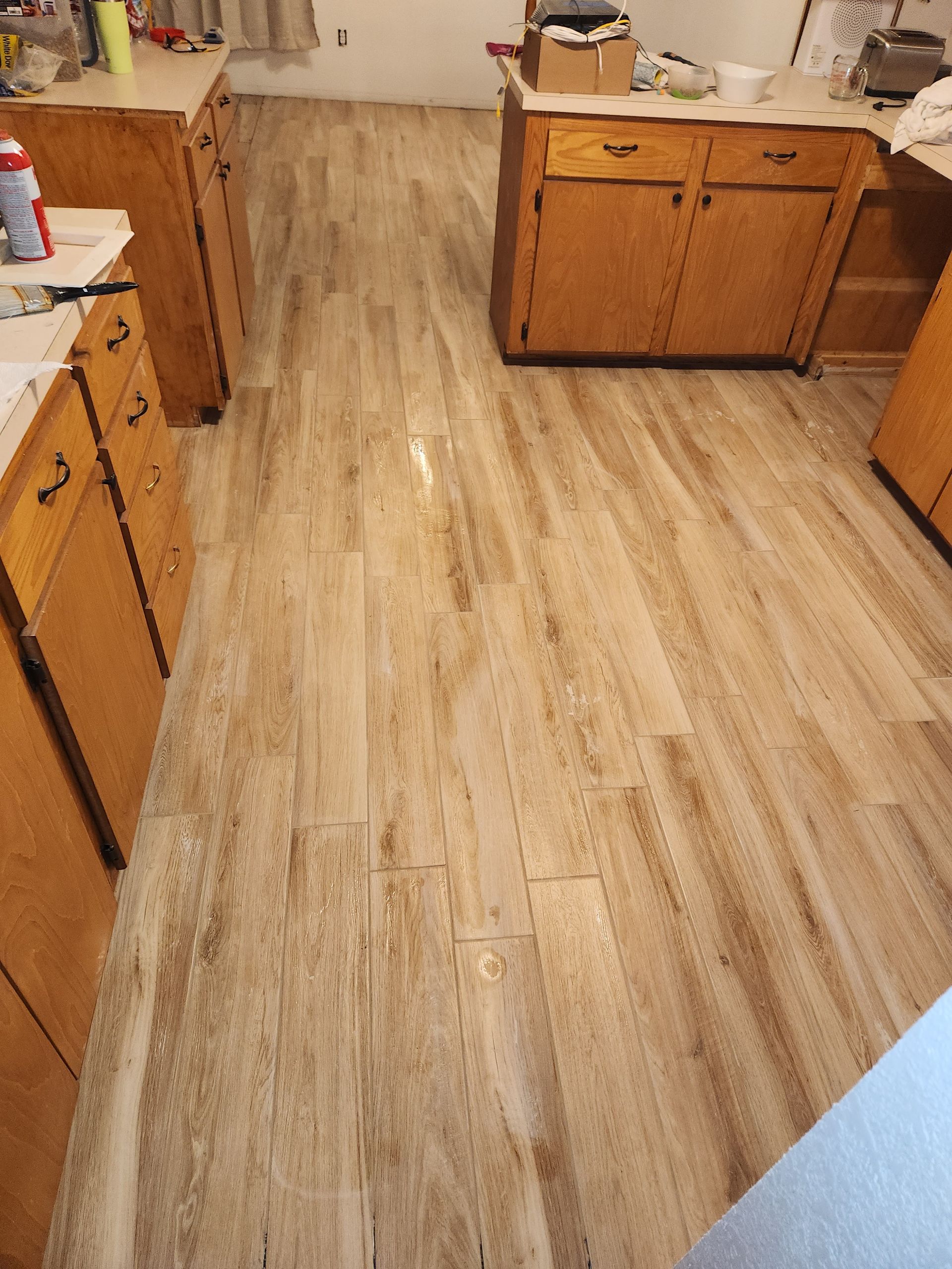 Kitchen with light wood cabinets and a light wood floor viewed from an open doorway