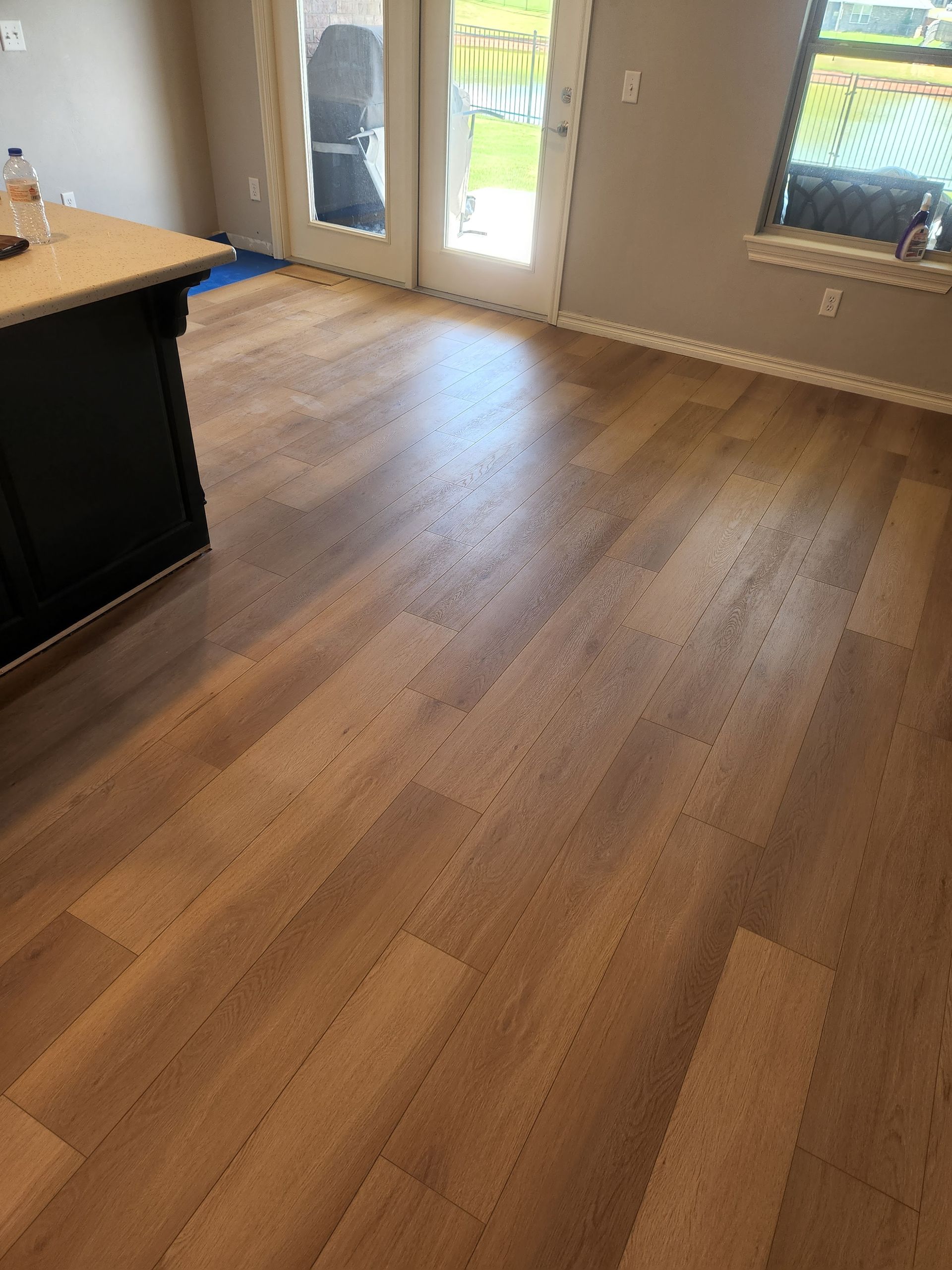 Empty room with wood floors, French doors, and windows letting in daylight