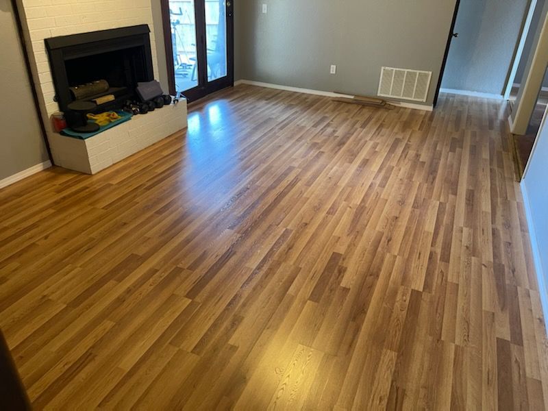 Empty living room with wood floors, fireplace, and sliding glass door.