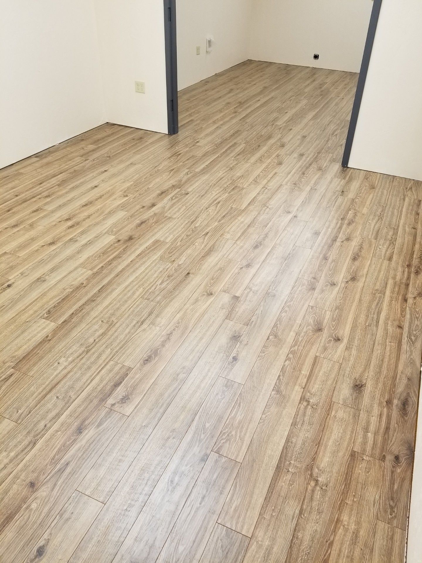 Empty room with light wood flooring and white walls