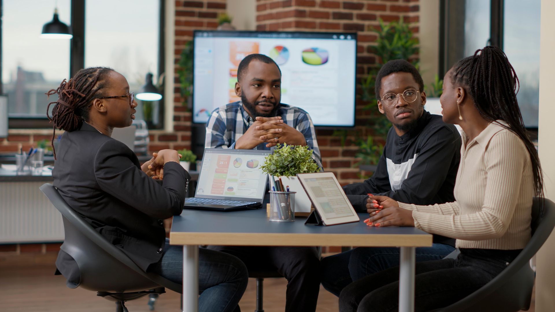 a group of people are sitting around a table having a meeting