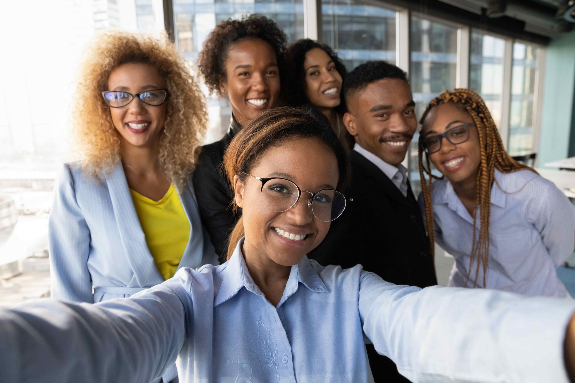 a group of business people are taking a selfie together in an office