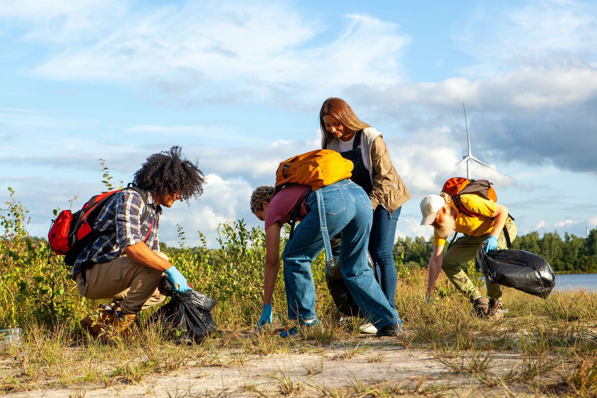 a group of people are picking up trash in a field