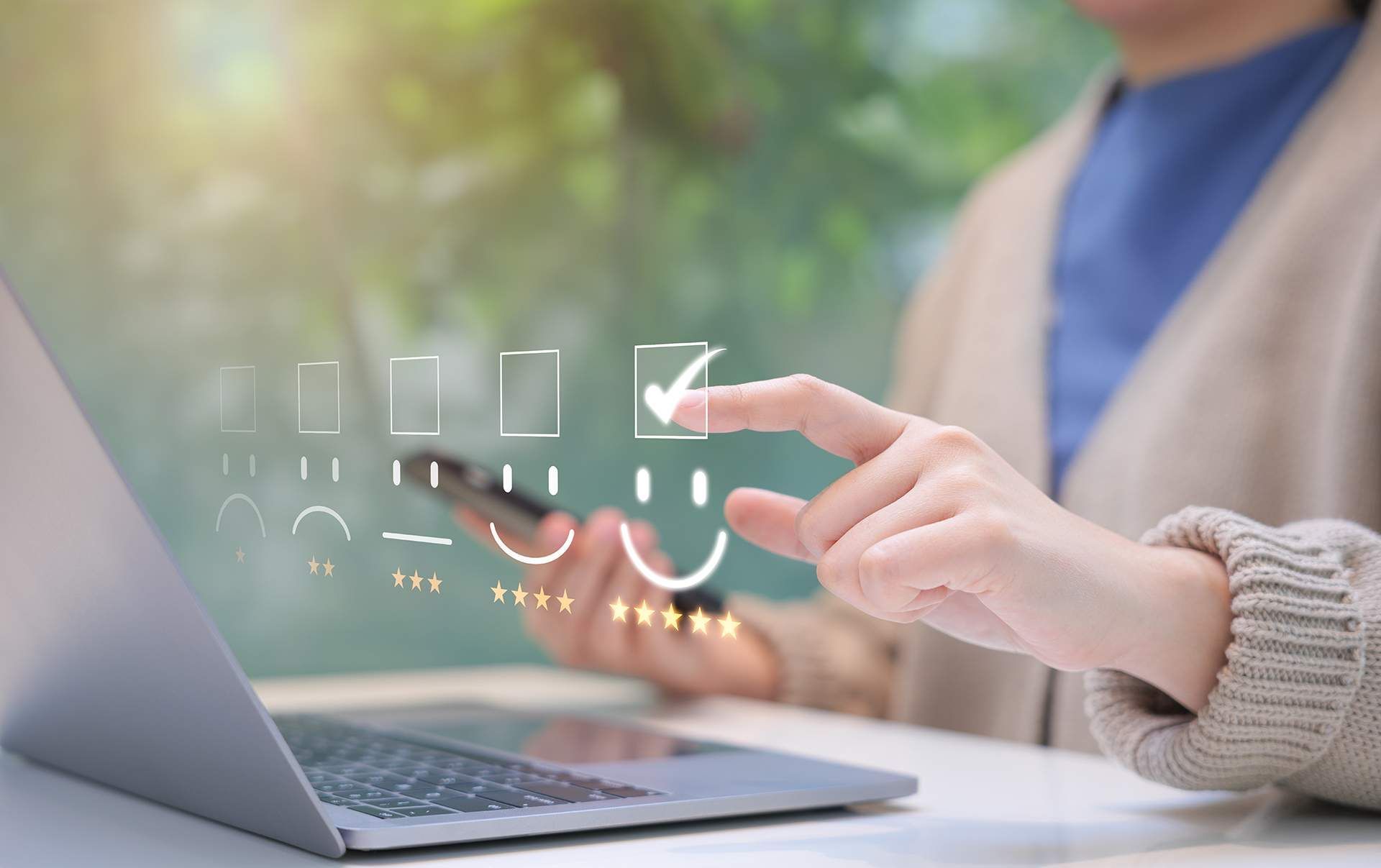 A woman is using a laptop computer and a cell phone.