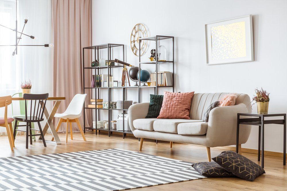 A Living Room with A Couch, Chairs, a Rug and A Clock on The Wall — Cachia Upholstery in Tuncurry, NSW