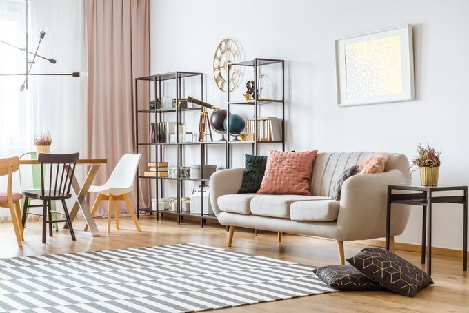 A Living Room with A Couch, Chairs, a Rug and A Clock on The Wall — Cachia Upholstery in Tuncurry, NSW