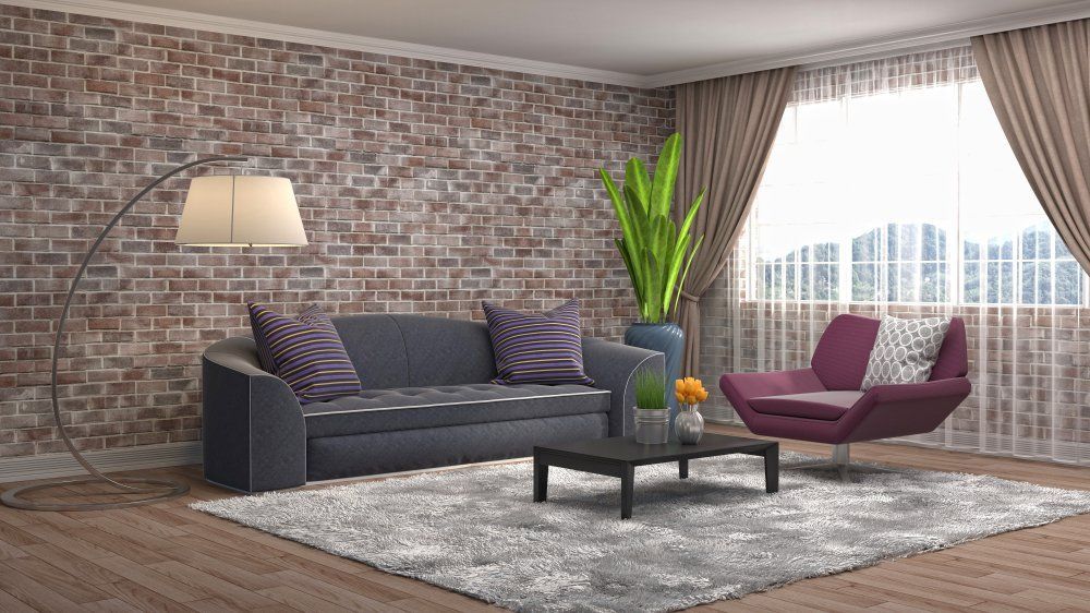 A Living Room with A Couch, Chair, Coffee Table and Brick Wall — Cachia Upholstery in Port Macquarie, NSW