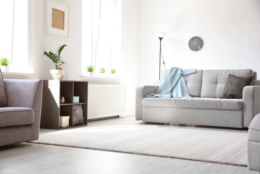 A Living Room with A Couch, Chair, and Rug — Cachia Upholstery in Taree, NSW