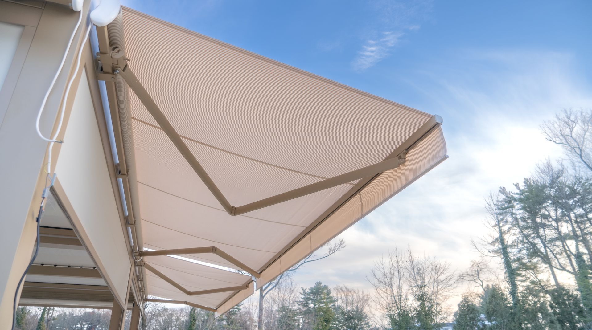 Beige Striped Patio Awning Extended Over a Deck — Cachia Upholstery in Forster, NSW