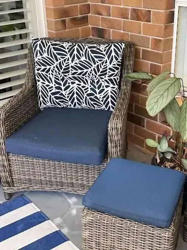 Wicker Chair and Ottoman with Blue Cushions on A Porch — Cachia Upholstery in Tuncurry, NSW