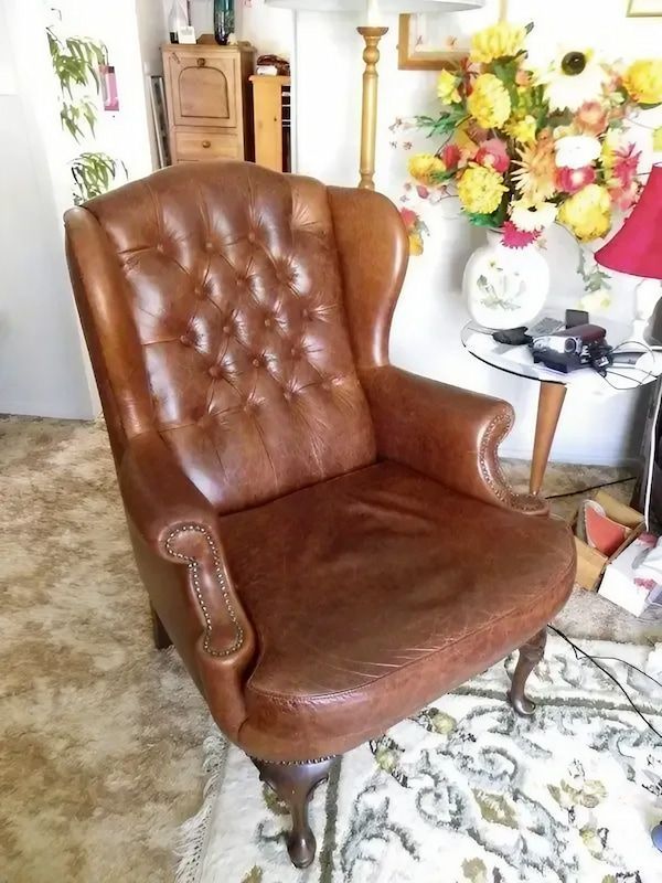 A Brown Leather Chair Is Sitting in A Living Room — Cachia Upholstery in Tuncurry, NSW