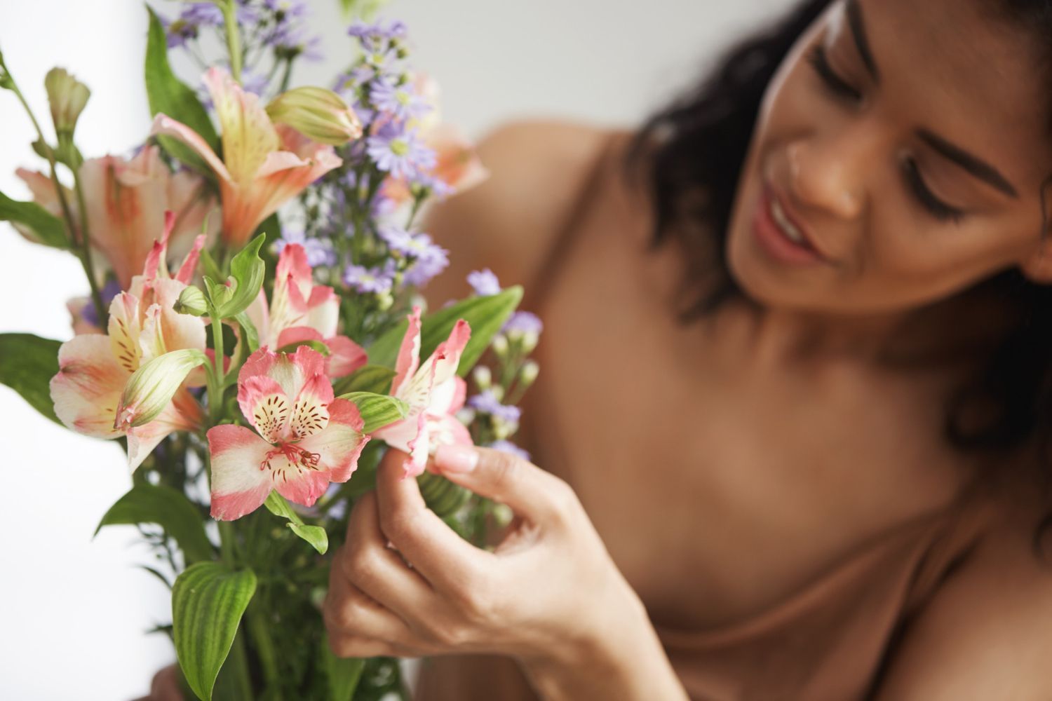A woman is holding a bouquet of flowers in her hands.