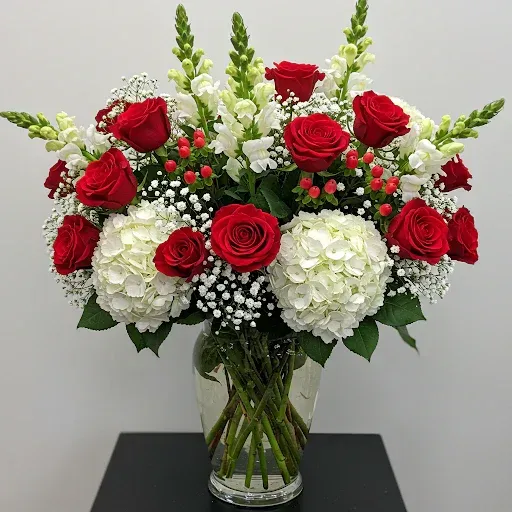 A person is holding a bouquet of eucalyptus wrapped in brown paper