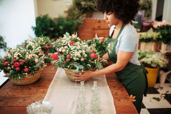 a person is arranging flowers on a wooden table