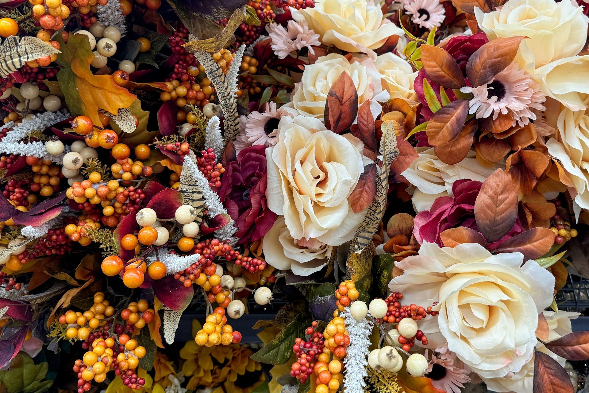 A bunch of flowers and berries are sitting on a table.