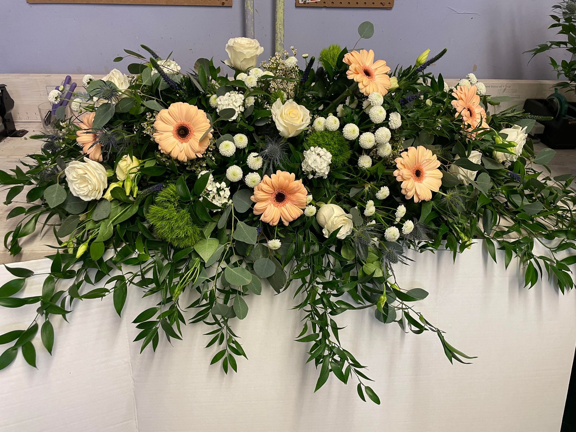 a large arrangement of flowers and greenery on a table