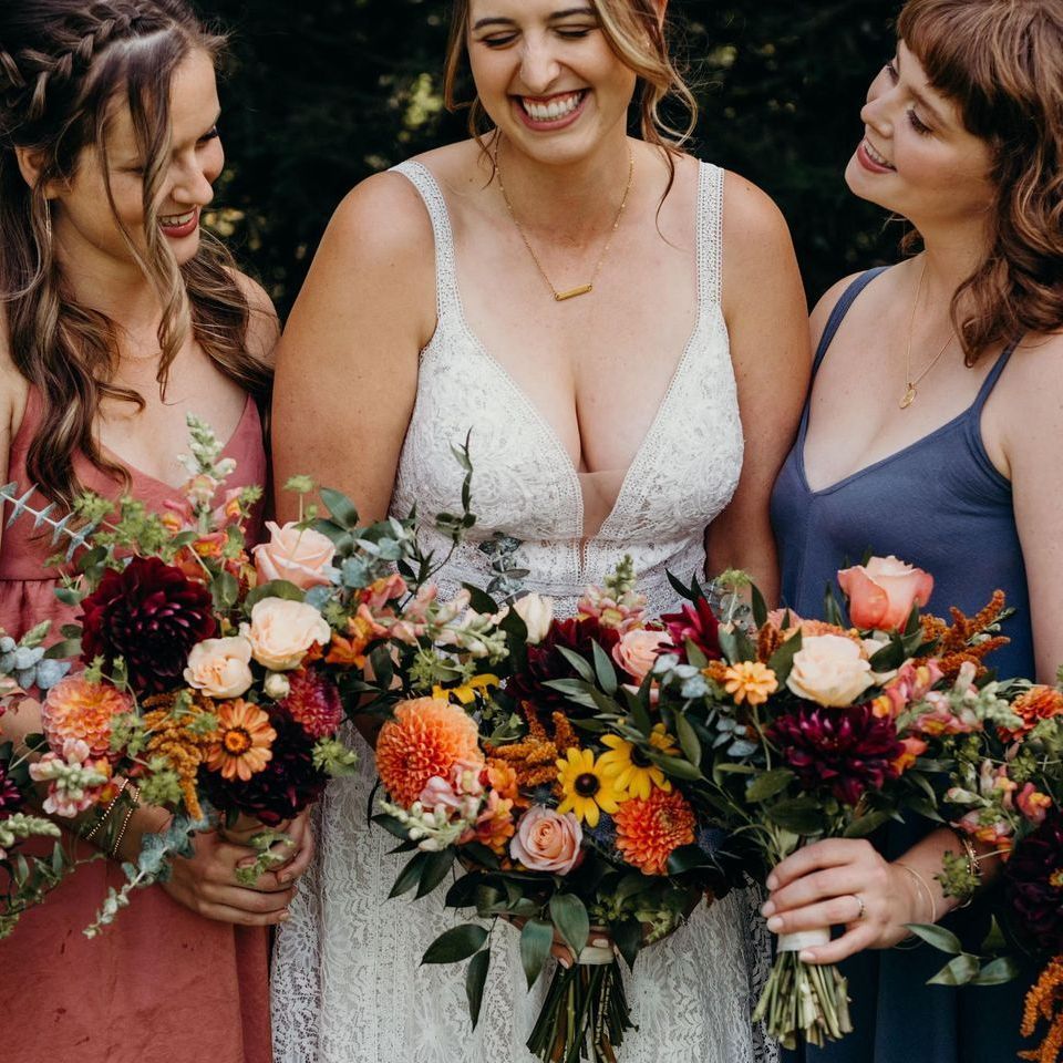 a bride and her bridesmaids holding bouquets of flowers