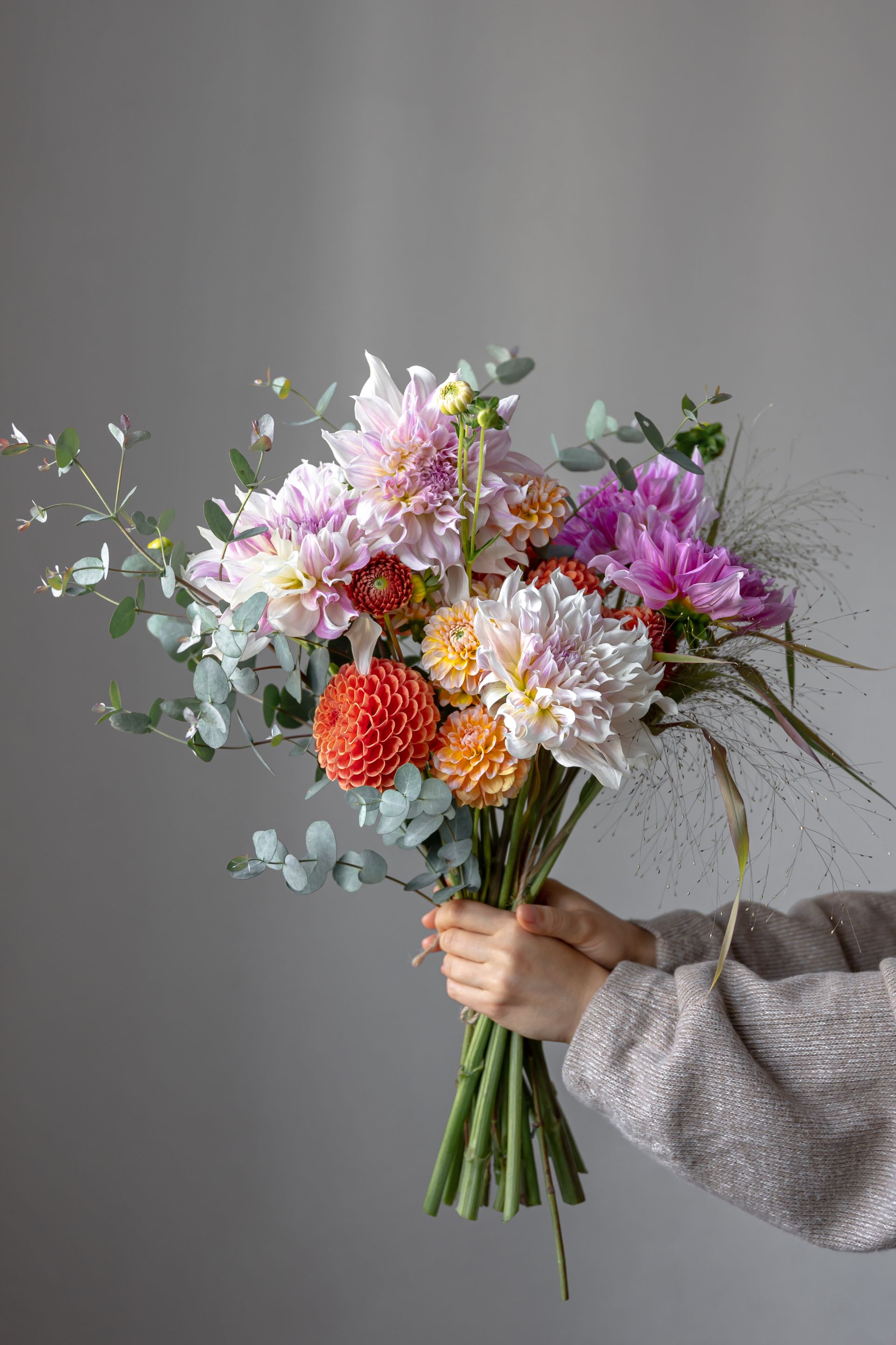 a person is holding a bouquet of flowers in their hands