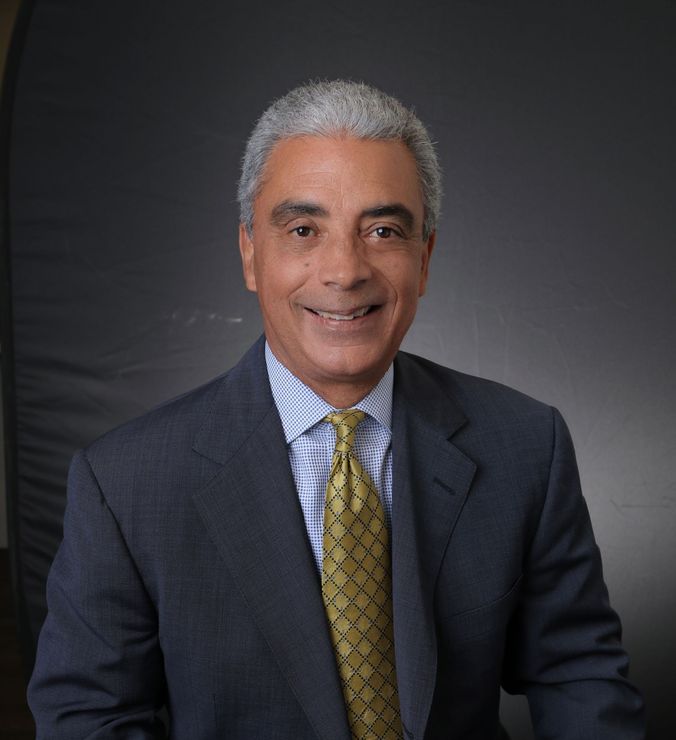 A man in a suit and tie is smiling for the camera