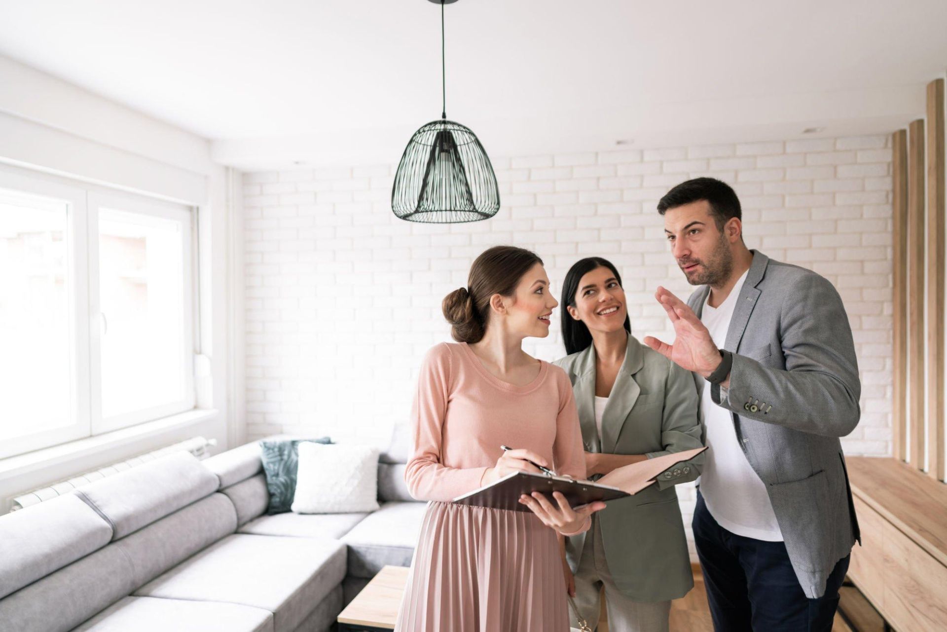 A man and a woman are looking at a living room with a real estate agent.