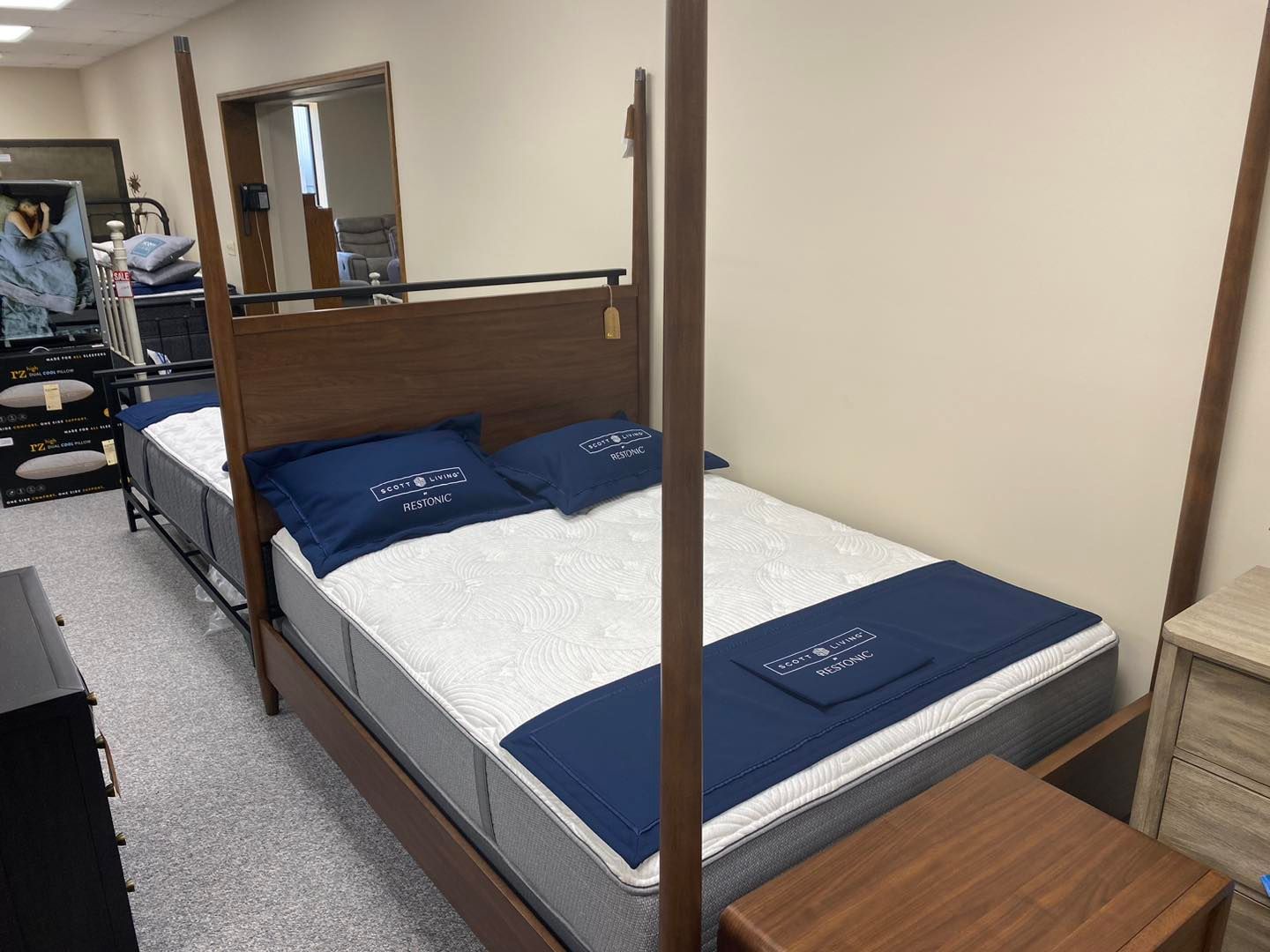 A four poster bed with a mattress and pillows in a room.