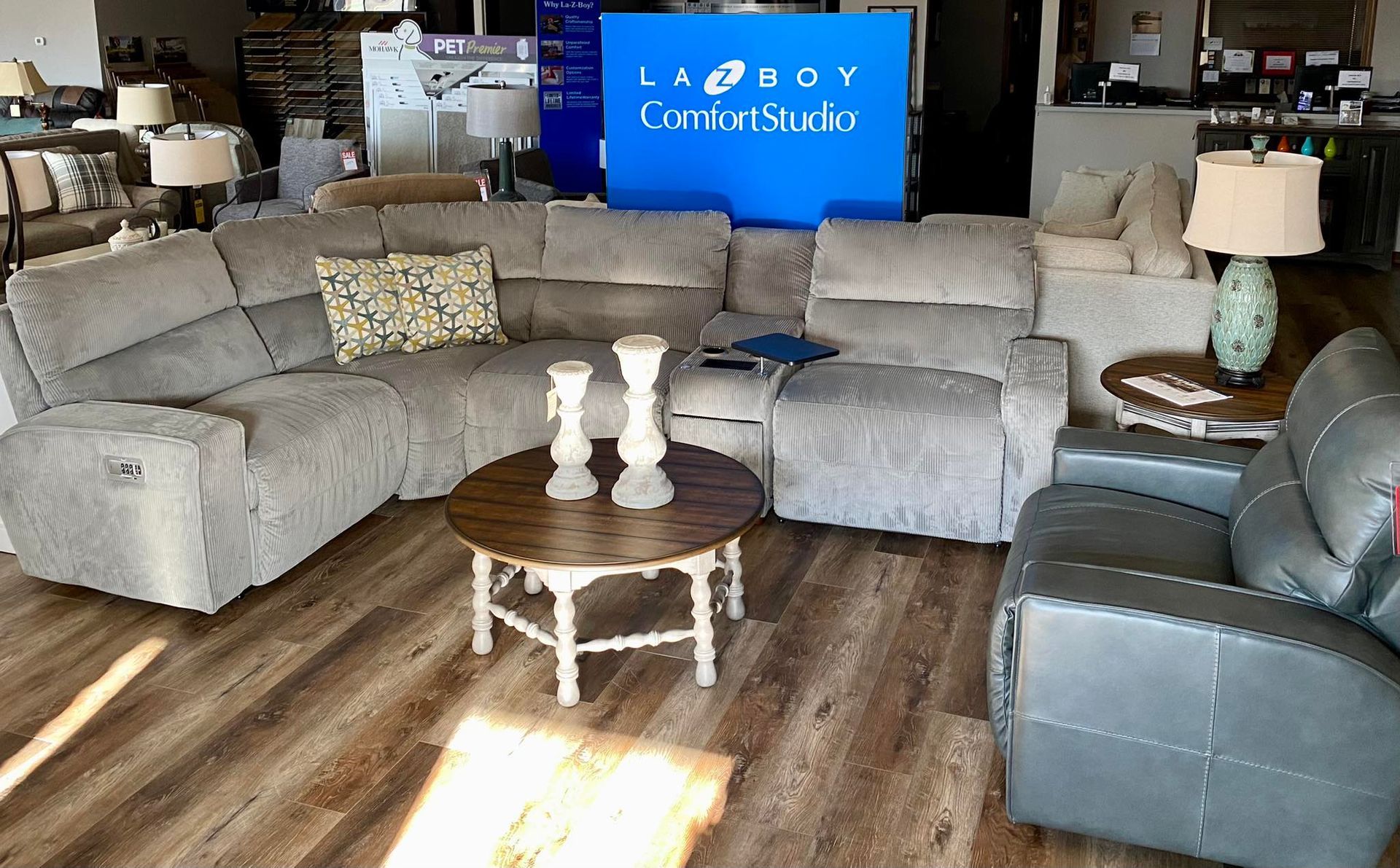 A living room with a couch , chair , coffee table and lamps.