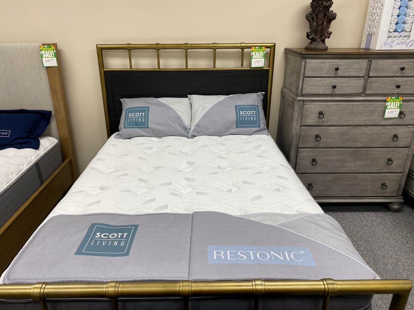 A bed with a mattress and pillows on it in a store.