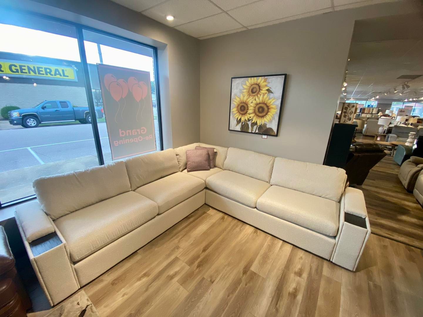 A white sectional couch is sitting in a living room next to a window.