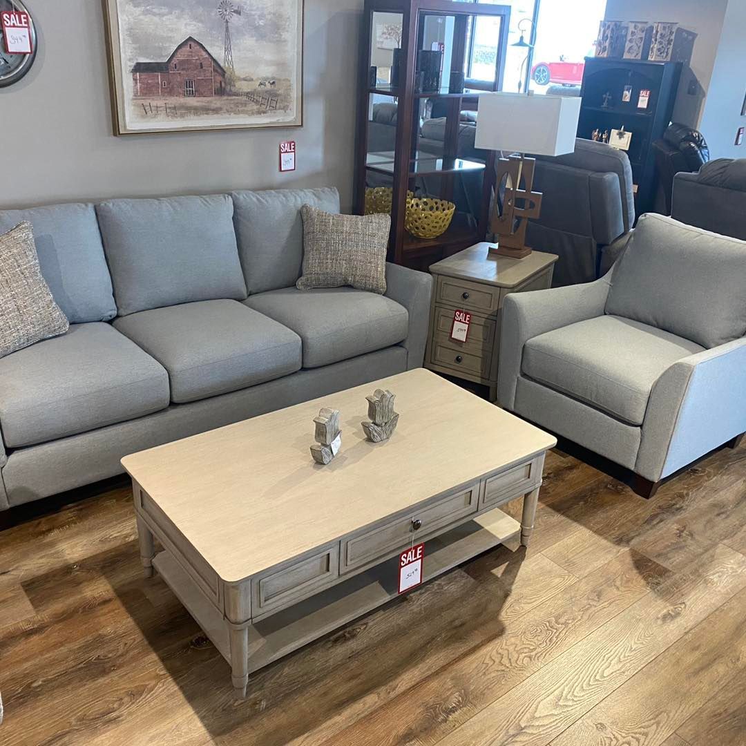 A living room with a couch , chair and coffee table