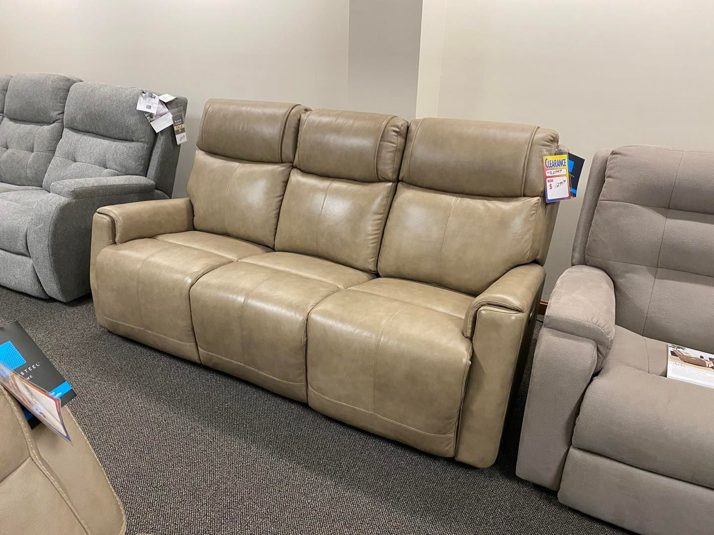 A couch is sitting in a living room next to a recliner.